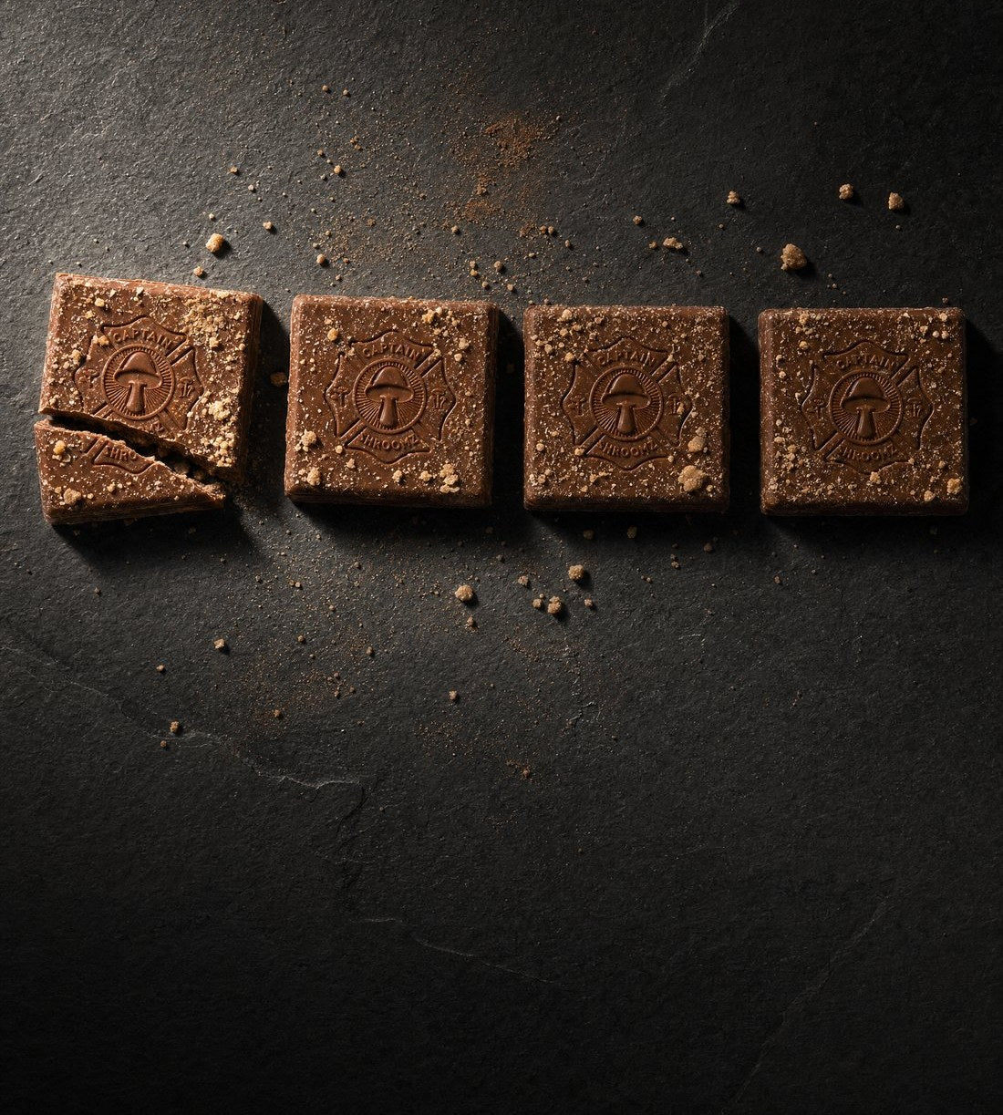 Overhead view of eight half-cubes of chocolate laid out on a 1970s wooden table
